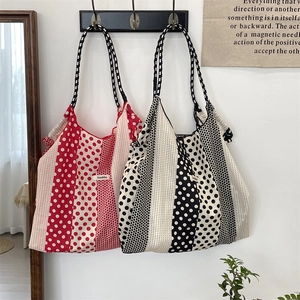 Détail de sacs fourre-tout en toile à pois rouges et noirs en décor intérieur
