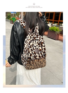 Dettaglio dello zaino in peluche leopardato con trama morbida e tasca frontale a zip