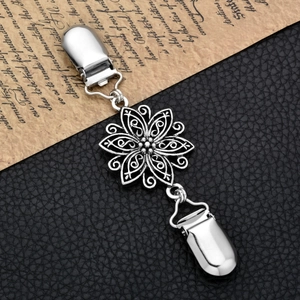 Detailed close-up of retro silver flower cardigan clip with dual duckbill fasteners