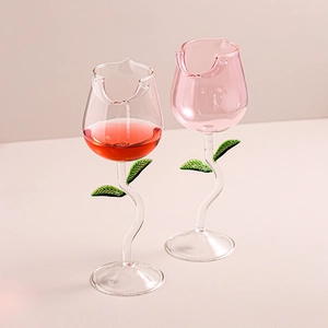 Elegant tulip shaped pink wine glass with green leaf stem and floral design