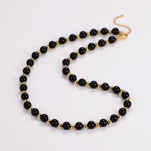 Macro detail of tiger eye and obsidian beaded necklace with golden lobster clasp finish