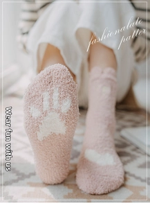 Detailed texture of thick pink coral fleece socks with cat paw prints for winter warmth