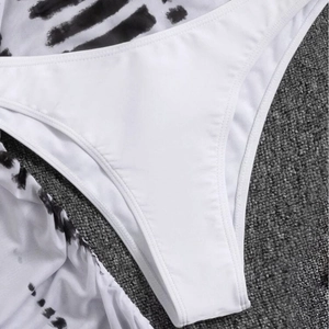Three-piece bikini set with white drawstring shorts and black tie-dye mesh cover-up