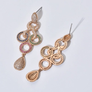 Close-up of rose gold tassel earrings with colorful zircons and drop-shaped crystal detail