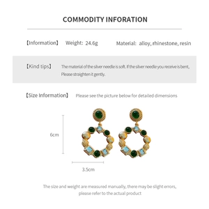 Detail view of vintage circle earrings with green resin and blue rhinestones