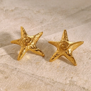 Macro detail of gold-plated starfish stud earring with elegant spiral texture