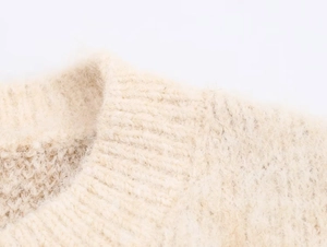 Close-up of cream knit sweater showing soft mohair texture and ribbed neckline detail