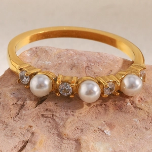 Macro shot of 18K gold plated ring with pearls and zircon on a textured stone base