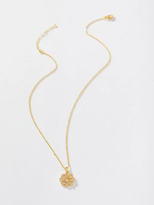 Close-up of a gold sunflower pendant with sparkling cubic zirconia on a delicate chain