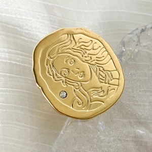 Macro detail of vintage gold coin ring featuring Venus relief and a small rhinestone