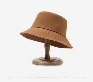 Detail of caramel bucket hat with dense stitching on a premium wooden display stand