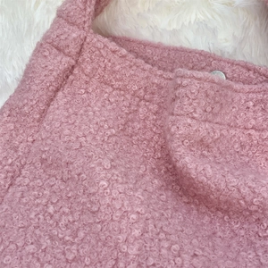 Macro detail of soft pink bouclé fabric on a chic autumn tote bag with plush texture