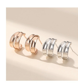 Macro shot of S925 sterling silver double-layered C-shaped stud earrings in gold and silver
