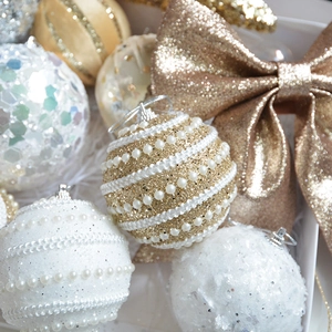 Macro shot of champagne gold Christmas tree ornaments with glitter and pearls in a gift box