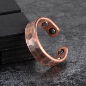 Macro shot of copper magnetic health ring with hammered texture and four inner magnets