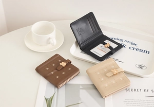 Three elegant small floral PU leather wallets with flower metal buckle on a desk