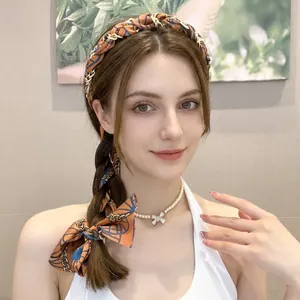 Detail of vintage chain pattern hairband with orange and blue silk ribbon ribbons