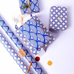 Blue geometric pattern gift wrapping paper roll with elegant gift box set and ribbons