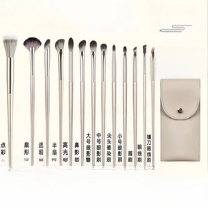 Close-up of a 13-piece mini champagne gold makeup brush set with beige leather pouch