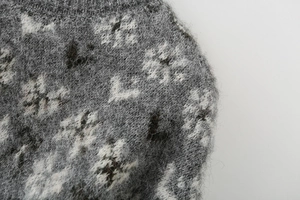 Macro view of gray and white floral jacquard knit sweater with fuzzy mohair texture