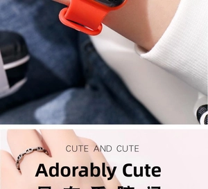 Detail of a bright orange silicone watch strap and a silver pig nose chain ring