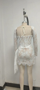 Détail du dos de la mini robe en dentelle blanche avec laçage corset et découpe au dos