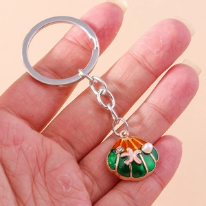 Detailed close-up of a pearl shell keychain featuring colorful starfish and rhinestones