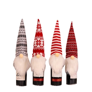 Set of four knitted Christmas gnome wine bottle covers with plush beards for festive decor