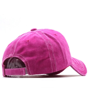 Close-up of distressed fuchsia baseball cap featuring vintage wash and white contrast stitching