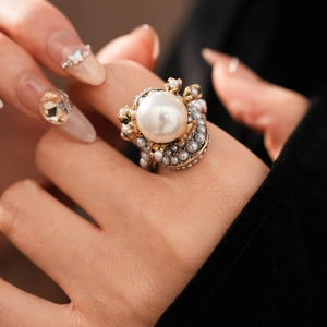 Macro shot of vintage pearl flower ring featuring grey beads and gold metal details