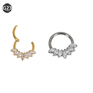 Detail view of G23 titanium clicker rings in gold and silver with marquise zircons