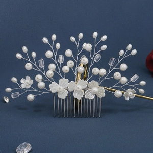 Detail of silver leaf hair comb with white flowers and pearls for bridal hairstyles