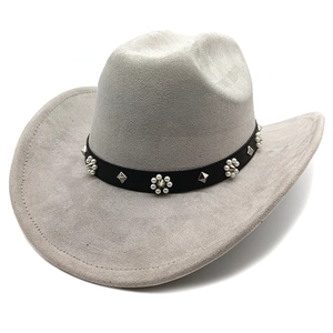 Détail d'un chapeau de cowboy en daim gris clair avec fleurs de perles et clous en métal