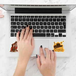 Flat lay of Western cowboy stickers on a white laptop with Sertanejo art and horse themes