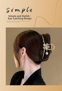 Close-up of an elegant gold metal hair claw clip with pearl and flower detail on hair