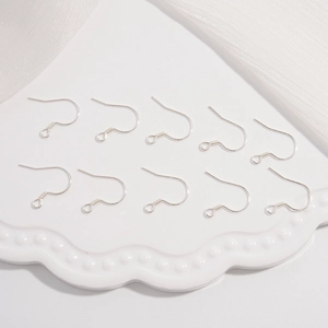Set of ten polished S925 sterling silver earring hooks arranged on a white textured tray