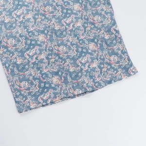 Vue détaillée du tissu bleu avec imprimé floral, rubans roses et motifs de cerfs