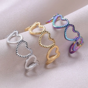 Detailed macro view of heart-shaped hollow rings in silver, gold, and aurora finishes
