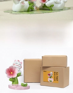 Detail showing resin pink cherry blossom cat phone holder with original brown packaging box