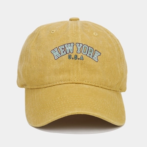 Close-up of ginger yellow washed cotton baseball cap with retro New York embroidery