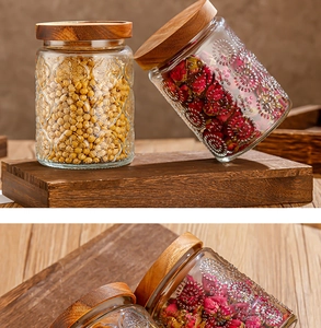 Close-up of glass storage jars with relief patterns and natural bamboo lids for kitchen