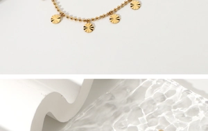 Detail of 18K gold plated beaded anklet with sunburst pattern disc pendants