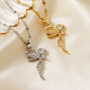 Detailed view of butterfly ribbon pendants with cubic zirconia on champagne silk fabric