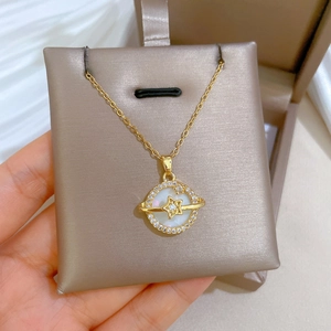 Detailed shot of golden planet necklace with white shell center and sparkling zircons
