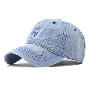 Detailed view of the washed denim fabric and navy blue N embroidery on a baseball cap