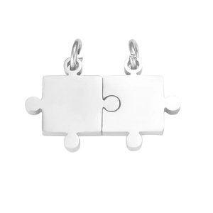 Detail of interlocking silver puzzle piece pendants in polished stainless steel