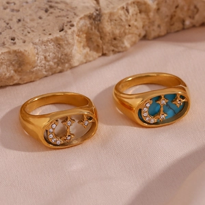 Detail view of gold rings with moon and star accents in white shell and blue turquoise