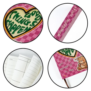Detail eines rosa karierten Notizbuchs mit Herzausschnitt und Good Things Happen Text