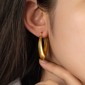 Elegant gold-plated chunky teardrop earrings with a smooth polished finish on model