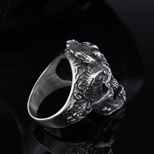 Vintage silver skull ring in stainless steel with detailed relief on a black base